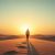 Persona solitaria caminando por el desierto con sol al atardecer